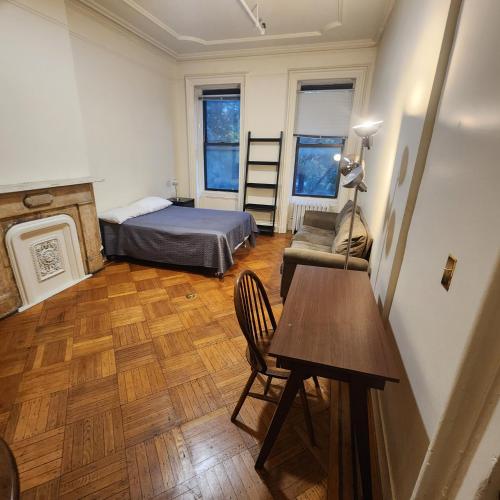 a bedroom with a bed and a table and a chair at New York City Guest House 2 in New York