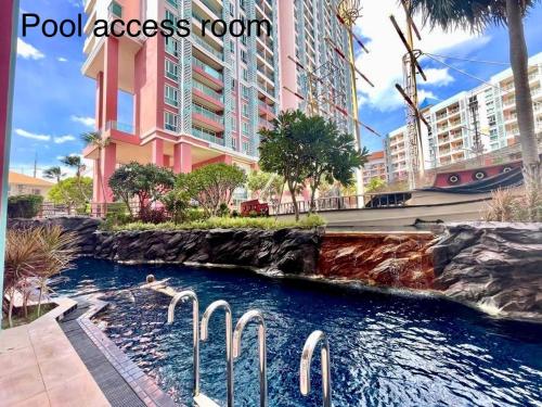 a pool in a resort with swans in the water at Grande Caribbean Condo Resort by PTN in Pattaya South