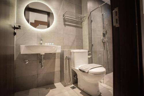 a bathroom with a toilet and a sink and a shower at K Avenue by Pinstay in Donggongon