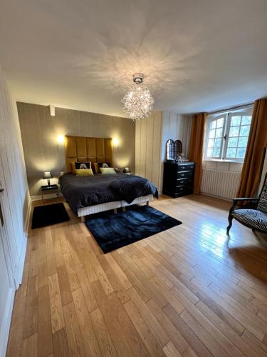 une chambre avec un lit et un lustre dans l'établissement Villa, à Agonges