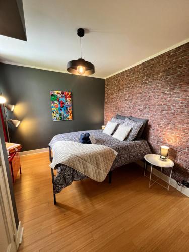 une chambre avec un lit et un mur de briques dans l'établissement Villa, à Agonges