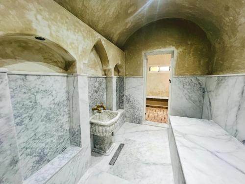 a bathroom with a tub and a sink at Ilafe Farmhouse, Villa avec piscine chauffée privée et Jacuzzi pour familles in Marrakesh