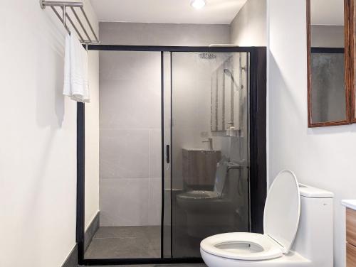 a bathroom with a toilet and a glass shower at Ponderosa Golf and Resort in Puerto Galera