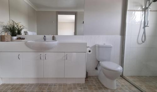 a white bathroom with a sink and a toilet at Stockyards 2, Jindabyne in Jindabyne