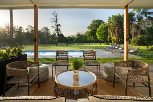 a patio with chairs and a table and a pool at Protea Hotel by Marriott George King George in George