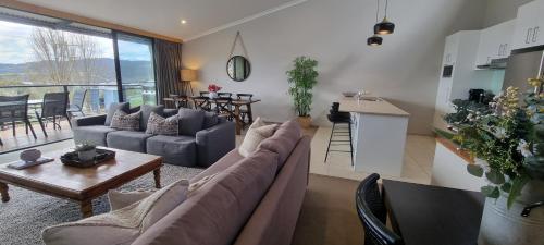 a living room with a couch and a table at Stockyards 2, Jindabyne in Jindabyne
