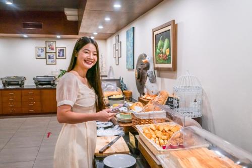 une femme debout devant un comptoir avec de la nourriture dans l'établissement Horizon Village & Resort, à Doi Saket