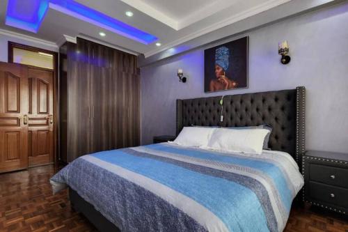 a bedroom with a large bed with a blue ceiling at Lovely Modern 2- bedroom apartment in Upperhill in Nairobi