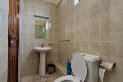 a bathroom with a toilet and a sink at Lovely Modern 2- bedroom apartment in Upperhill in Nairobi