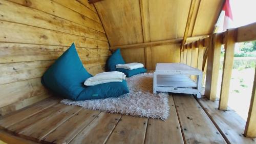 a room with blue pillows and a table in a cabin at Raturinjani homestay in Selong