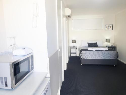 a bedroom with a bed and a sink and a television at Comfort Inn May Park in Horsham