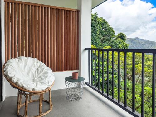 a room with a balcony with a chair and a view at Ponderosa Golf and Resort in Puerto Galera