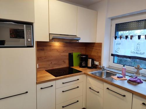 a kitchen with a sink and a microwave at Sarah klein aber fein in Wellesweiler