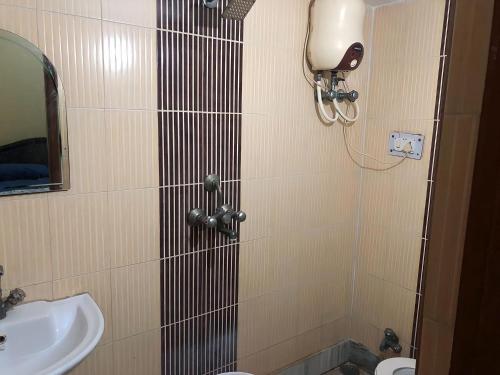 a bathroom with a sink and a toilet and a mirror at Shastreey Sangeet Nivas in Vrindāvan