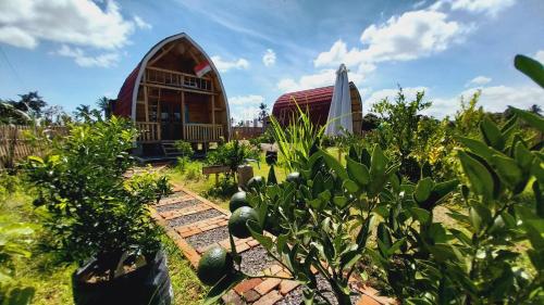 a garden with a building in the background at Raturinjani homestay in Selong