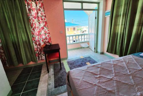 a bedroom with a bed and a view of a balcony at C&M Suites in Roseau