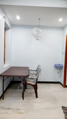 a table and a chair in a room with a sink at adhirai's home stay in Pondicherry