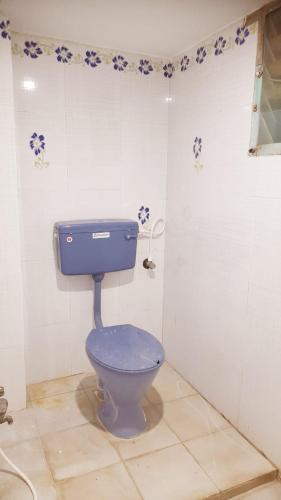 a bathroom with a blue toilet in a room at adhirai's home stay in Pondicherry