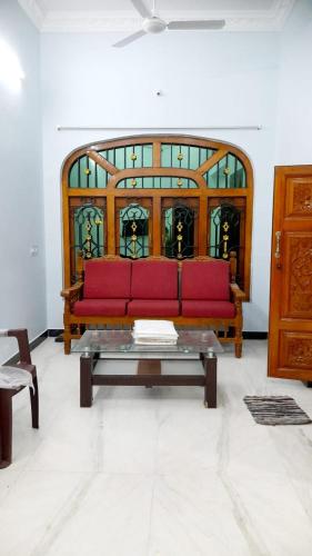 a red couch in a room with a stained glass window at adhirai's home stay in Pondicherry