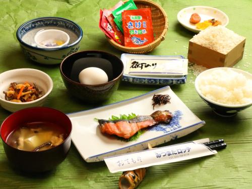 una tavola ricoperta di ciotole di cibo in cima a un tavolo di みつまたロッヂ a Yuzawa