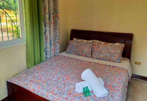 a bed with two towels and two bottles on it at Camotes Serenity in Camotes Islands