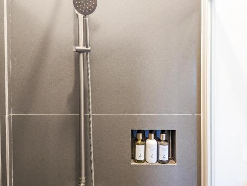 a shower with four bottles on a shelf in a bathroom at Ponderosa Golf and Resort in Puerto Galera