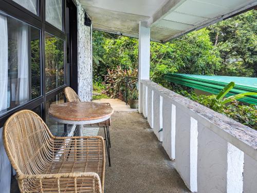 a table and chairs on the porch of a house at Ponderosa Golf and Resort in Puerto Galera