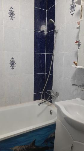 uma casa de banho com uma banheira e um lavatório em Двухкомнатная в 4 микрорайоне em Oral