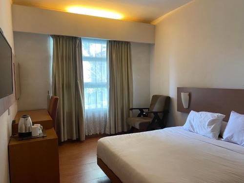 a hotel room with a bed and a window at Regato Suites in Jakarta