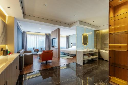 a large bathroom with a tub and a bedroom at Holiday Inn Express Lanzhou Zhengning Road, an IHG Hotel in Lanzhou