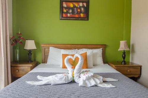 um quarto com dois cisnes feitos de toalhas numa cama em Hotel La Casa de la Abuela em Boquete