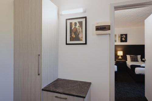 een badkamer met een aanrecht en een kamer met een bed bij Comfort Inn Traralgon in Traralgon