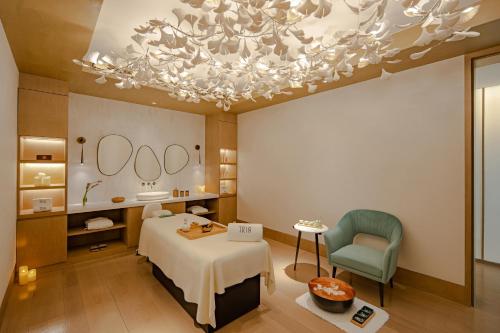 a bedroom with a bed and a chandelier at MGM Shanghai West Bund in Shanghai