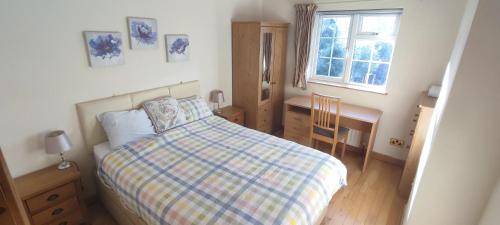 1 dormitorio con cama, escritorio y ventana en Shear Annexe Flat, en Cambridge