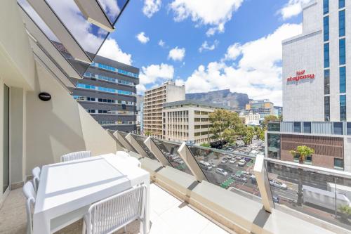 a balcony with chairs and a view of a city at The Barracks Apartments in Cape Town