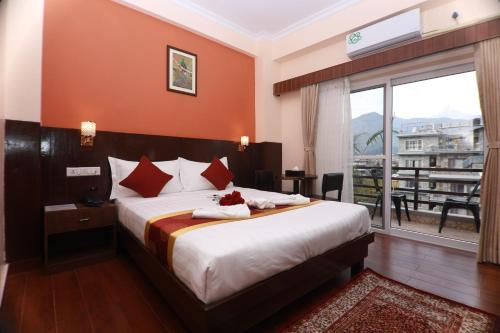 a hotel room with a bed and a large window at Hotel Eco Tree Pokhara in Pokhara