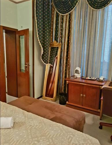 a bedroom with a bed and a mirror and a dresser at HOTELS ELSA in Skopje