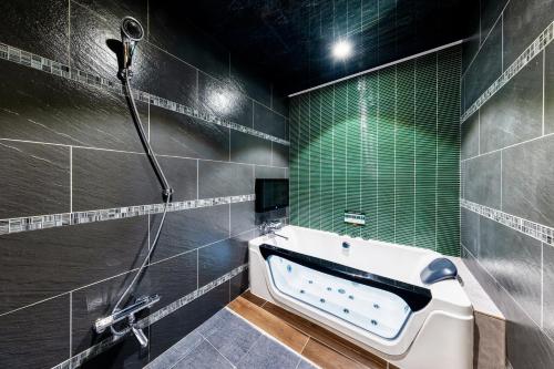 a bathroom with a bath tub and a shower at Hotel Artia Dinosaur hirakata -Adult Only in Hirakata