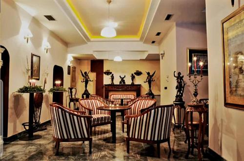 a lobby with chairs and a table and a fireplace at HOTELS ELSA in Skopje