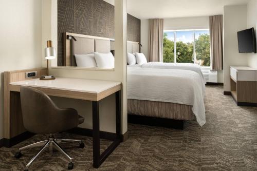 a hotel room with a bed and a desk and a desk at SpringHill Suites Dallas Arlington North in Arlington