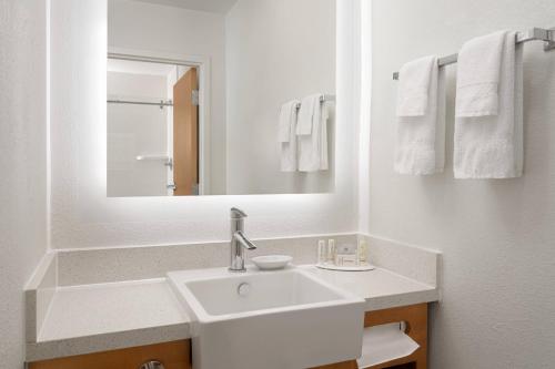 Baño blanco con lavabo y espejo en SpringHill Suites Dallas Arlington North en Arlington