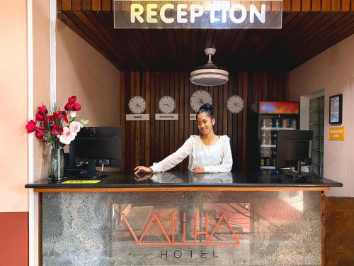 アンタナナリボにあるValiha Hotel Antananarivoのホテルのカウンターの後ろに立つ女
