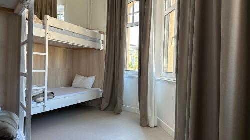 a small bedroom with a bunk bed and a window at La Brasserie Hostel in Metz