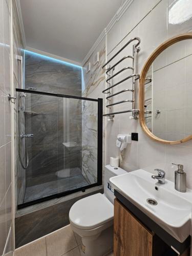 y baño con ducha, aseo y lavamanos. en Petropavlivska apartment, en Kamianets-Podilskyi