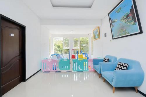 a living room with chairs and a window at RedDoorz near Jawa Timur Park 2 in Malang