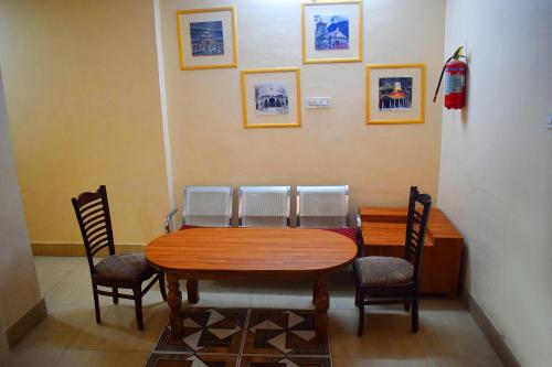 a dining room table with chairs and a wooden table at Hotel Golden in Haridwār
