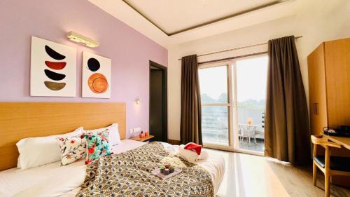 sypialnia z łóżkiem i dużym oknem w obiekcie ZEN Medicity - Hotel & Serviced Apartments Gurgaon w mieście Gurgaon
