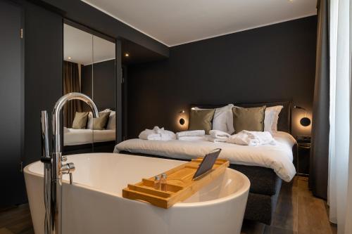 a hotel room with a tub and a bed at Sellmann´s Boutique Hotel in Dortmund