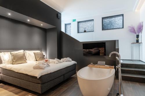 a bedroom with a bed and a bath tub at Sellmann´s Boutique Hotel in Dortmund