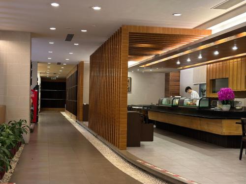 a lobby of a hotel with a man standing at a counter at Dongguan Richwood Garden Hotel in Dongguan
